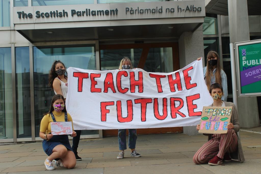 Teach the Future campaigners hold a banner outside Scottish Parliament